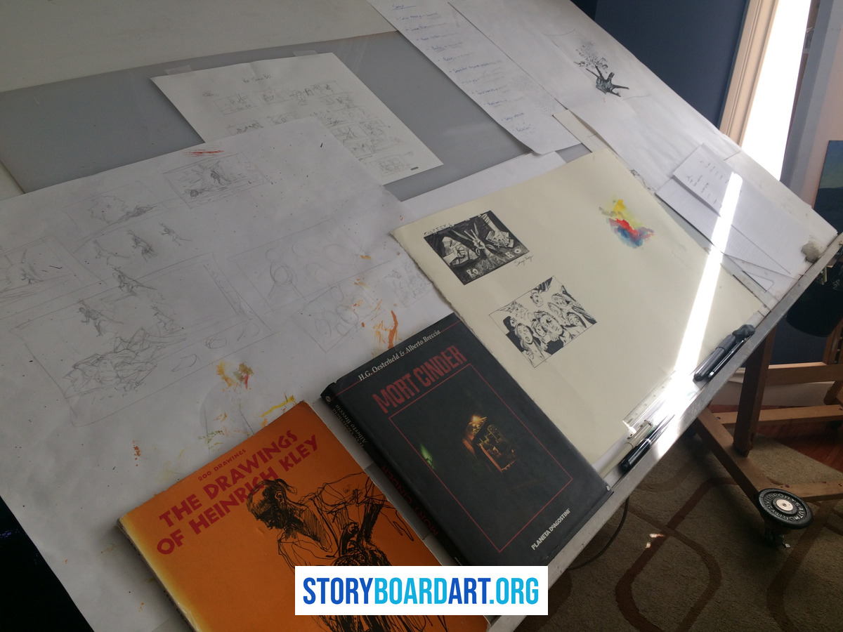 How to make a storyboard on a Word document that actually holds up 1 A slanted drafting table scattered with storyboard sketches, layout papers, and art books.
