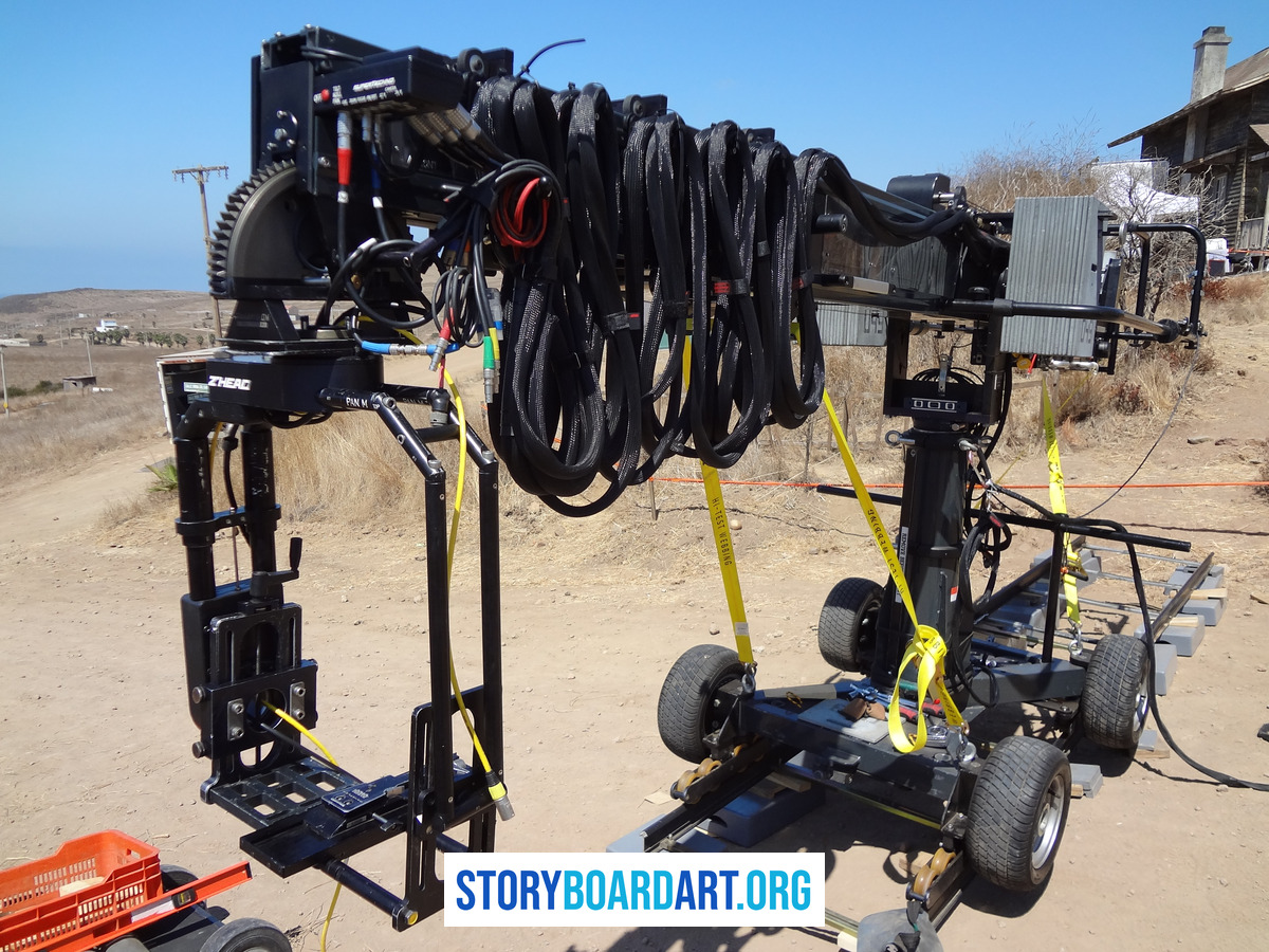 What Is a Tracking Shot? (And How It Differs From a Dolly) 1 A large professional camera crane and dolly rig set up outdoors on dirt tracks.